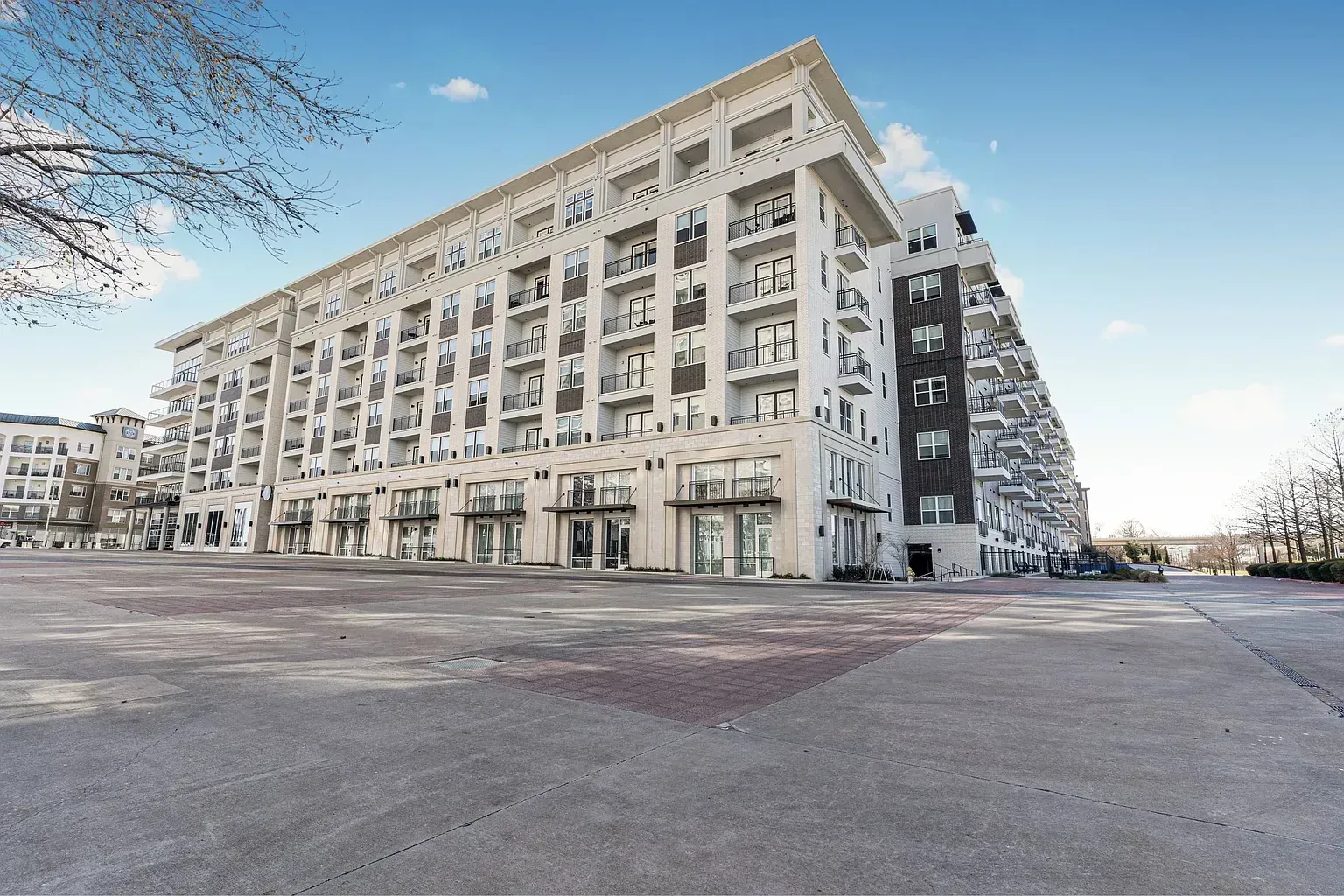 Exterior view of a modern apartment building with multiple balconies and large windows.
