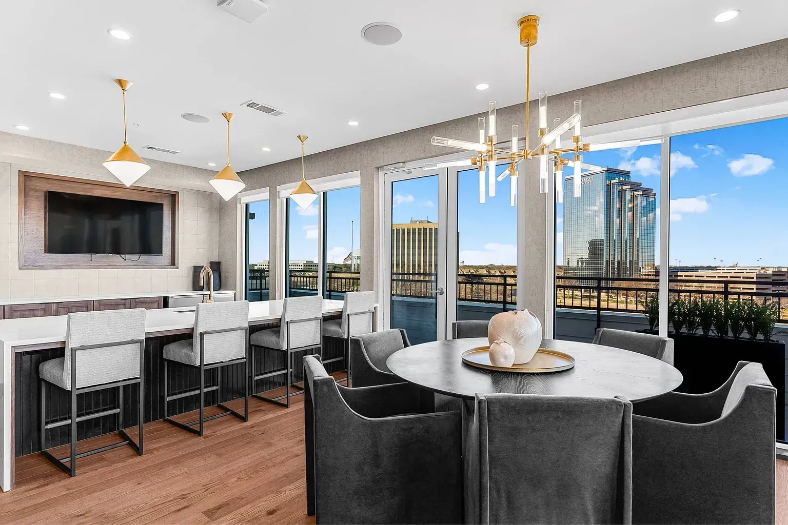Modern resident lounge with bar seating, dining area, and city views.