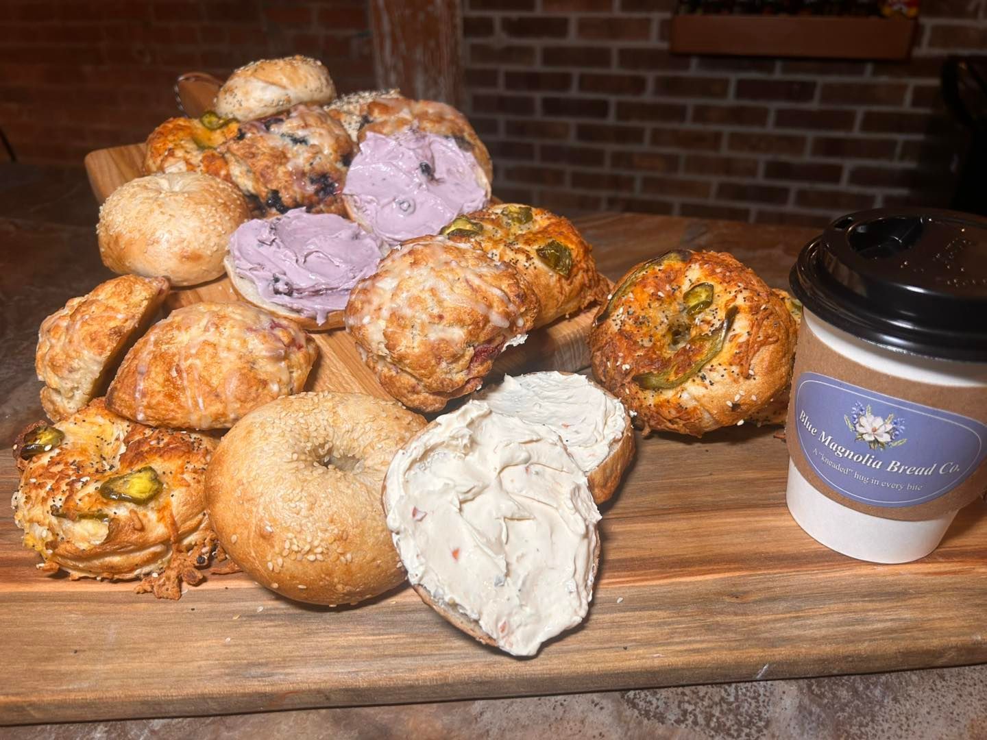 A wooden cutting board topped with a variety of pastries and a cup of coffee.