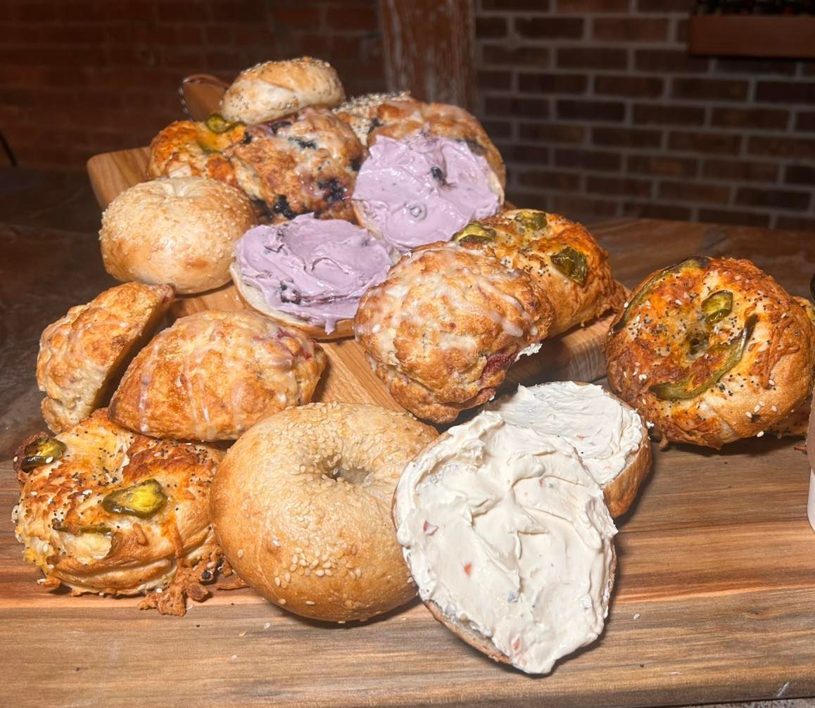 A bunch of different types of pastries are sitting on a wooden table.