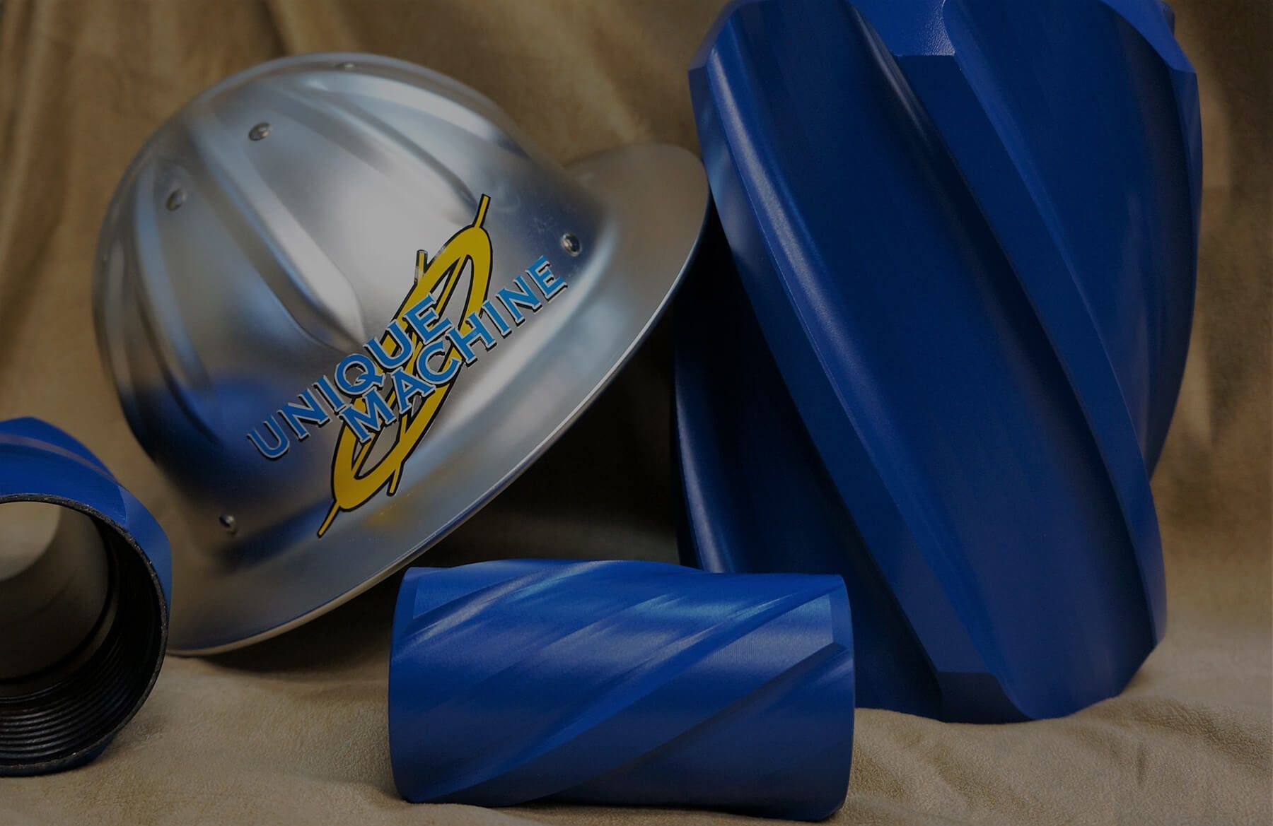 A hard hat is sitting next to some blue pipes