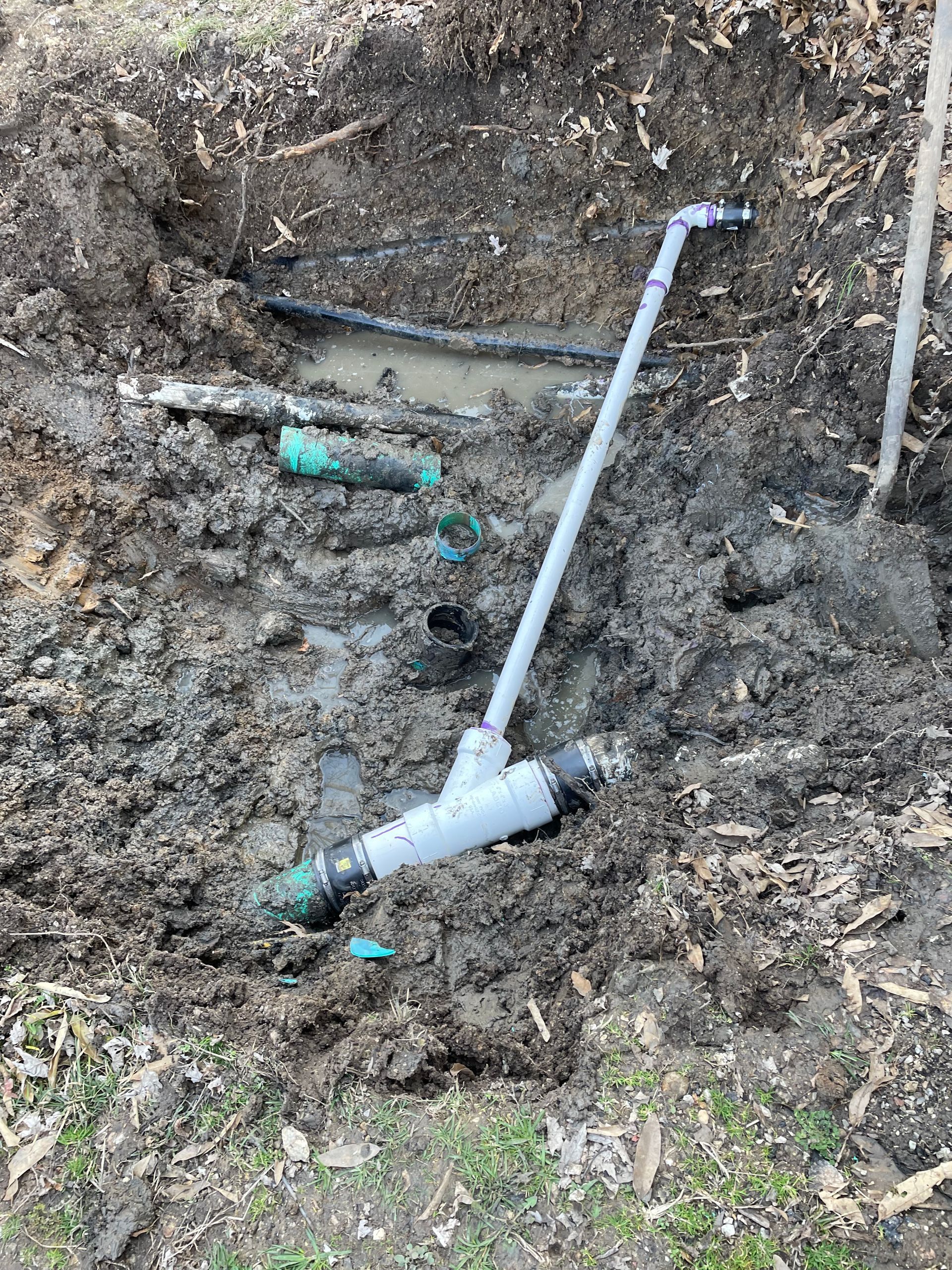 A pipe is sticking out of the ground in the dirt.