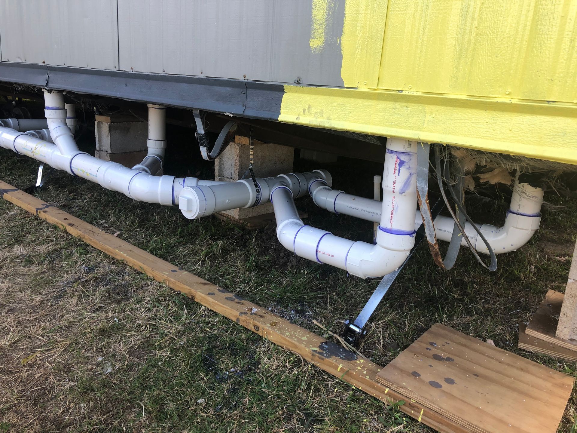 A bunch of white pipes are connected to a building.
