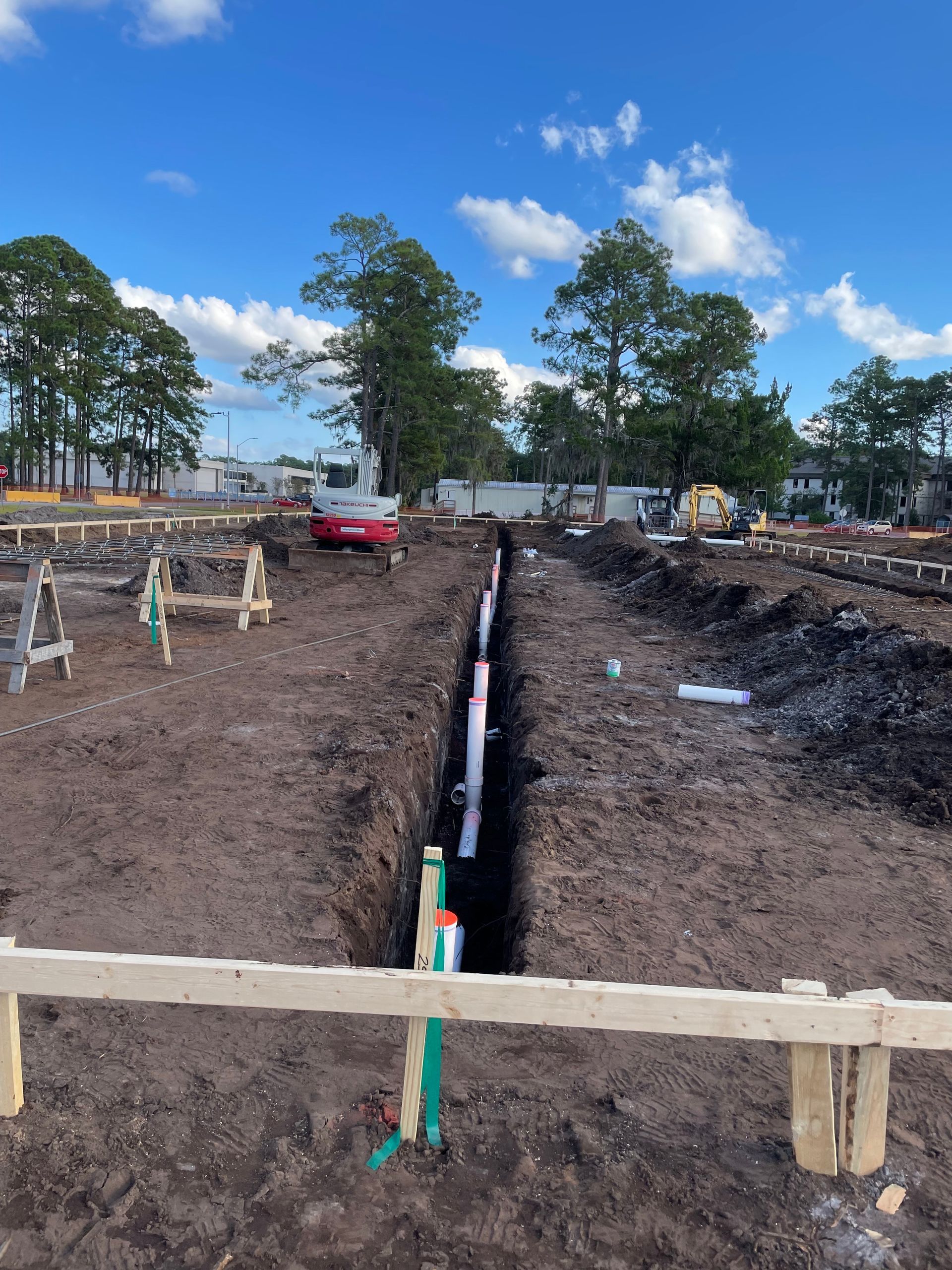 A construction site with a wooden fence and trees in the background