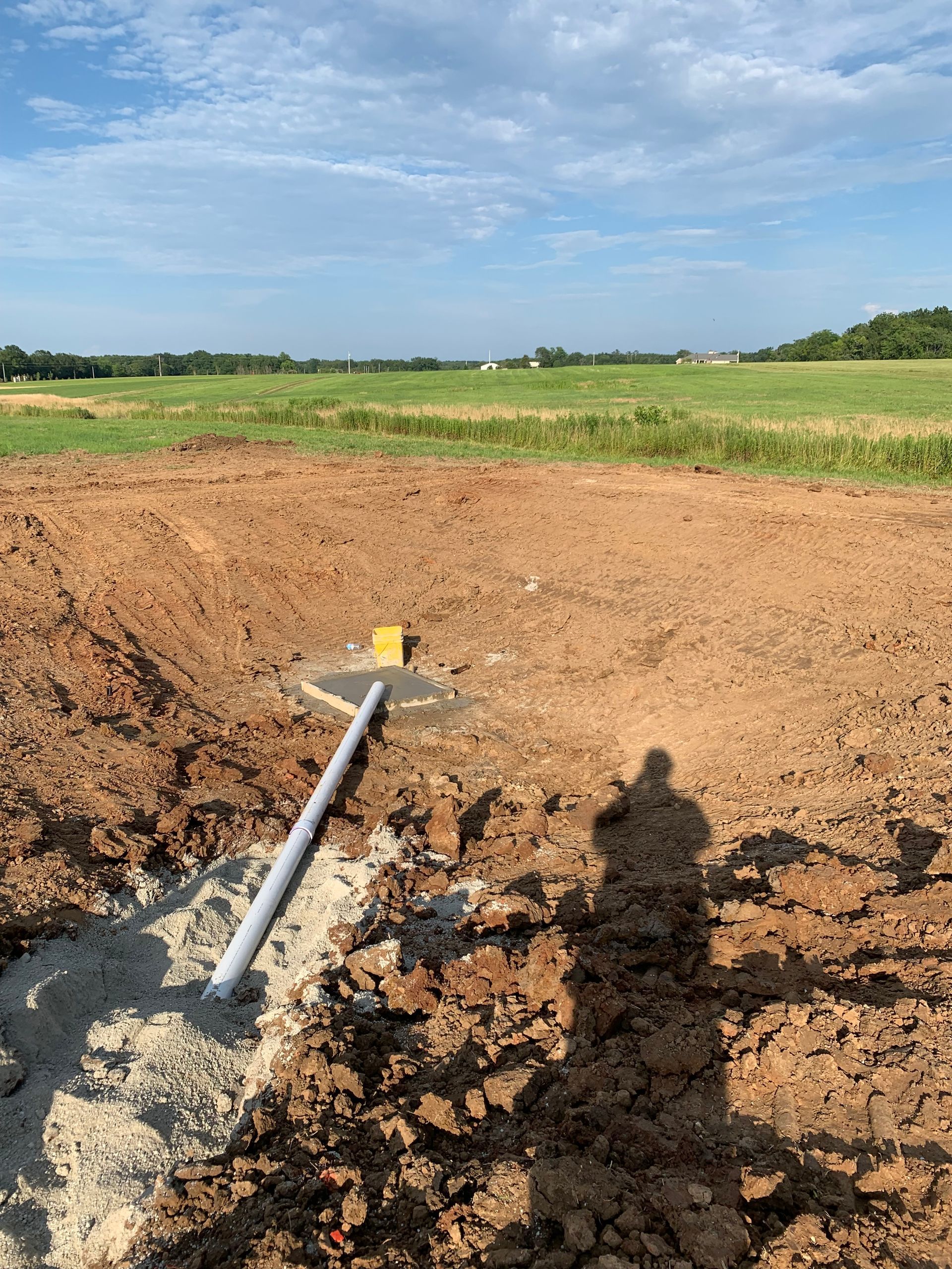 A pipe is sitting in the middle of a dirt field.