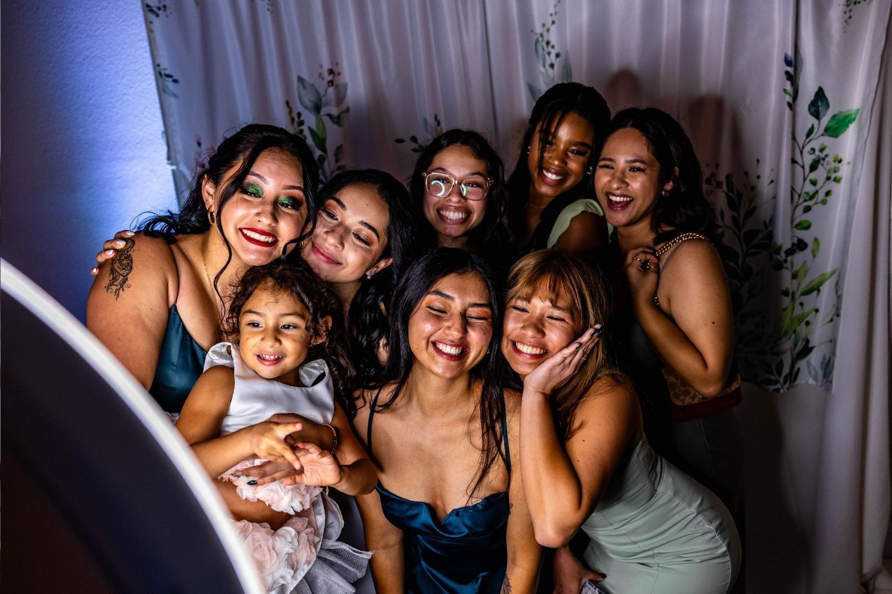 school dance with people taking a picture smiling with photo booth