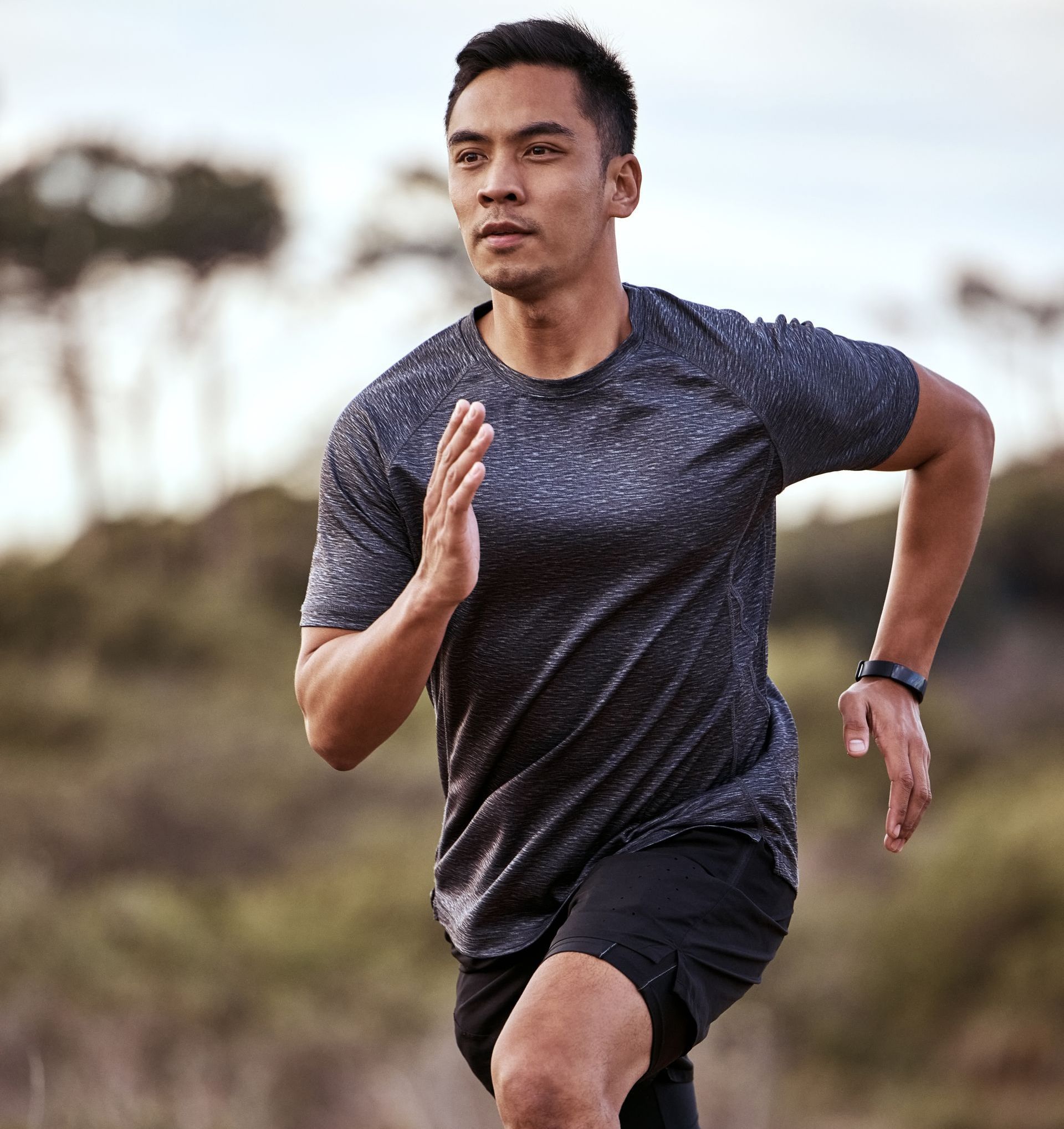 A man is running on a dirt path in a field.