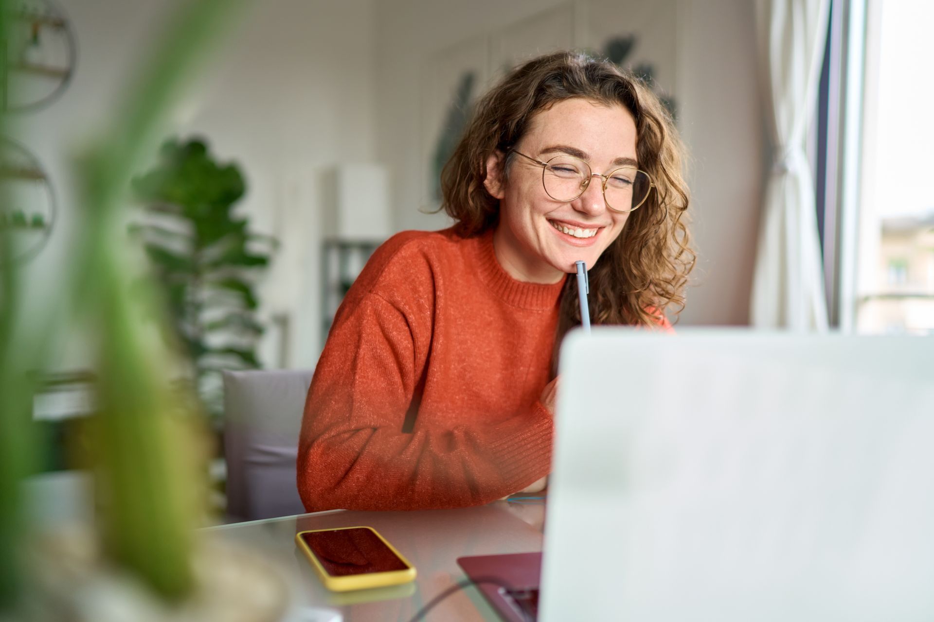 A woman is sitting at a table using a laptop computer.