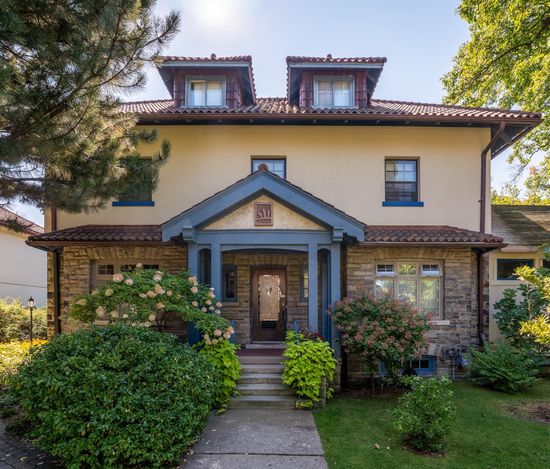 A two-story house with a stone and stucco exterior