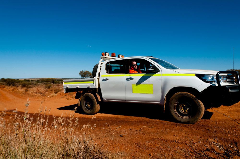 A White Truck is Driving Down a Dirt Road — Hastings Valley Powdercoaters in Taree, NSW