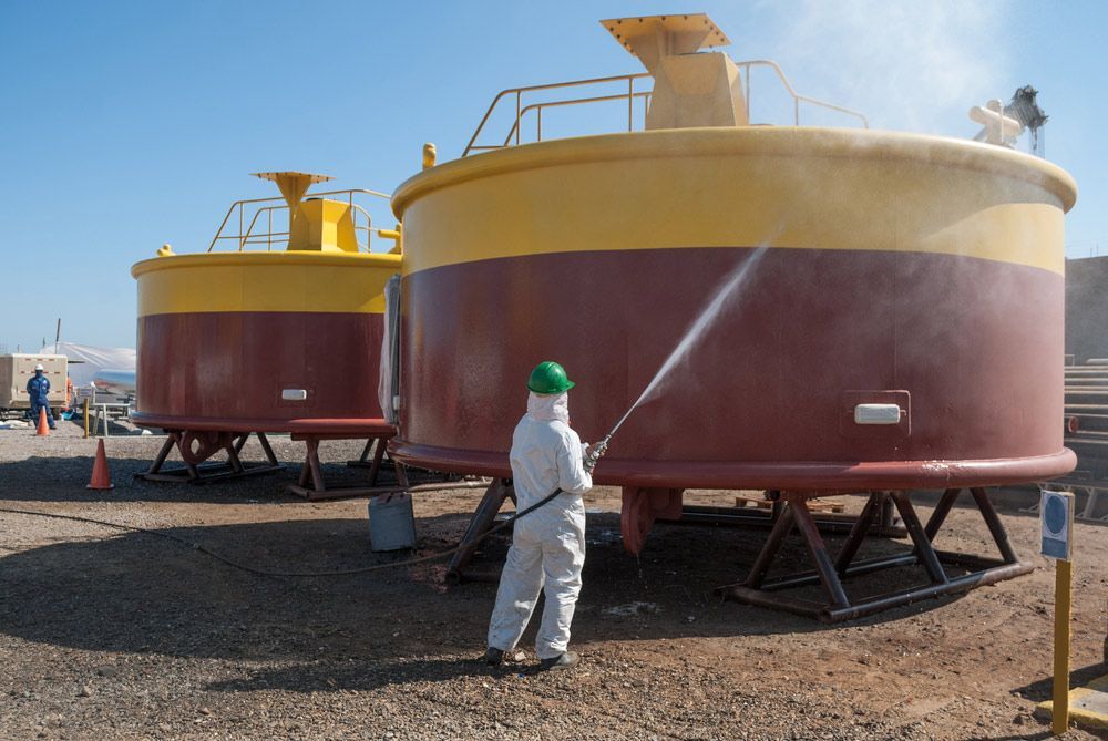 A Man in a Protective Suit is Sandblasting a Large Tank — Hastings Valley Powdercoaters in South West Rocks, NSW