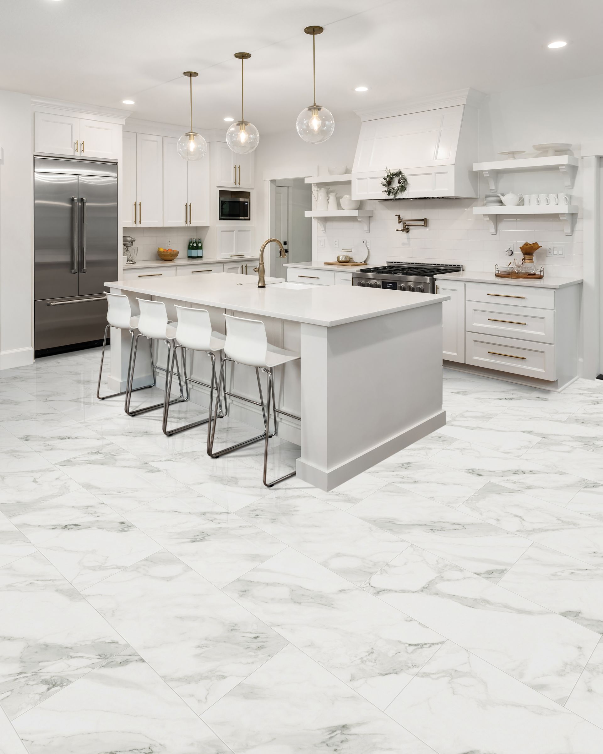 Bright modern white kitchen with marble floors, island seating, pendant lights, and stainless steel appliances
