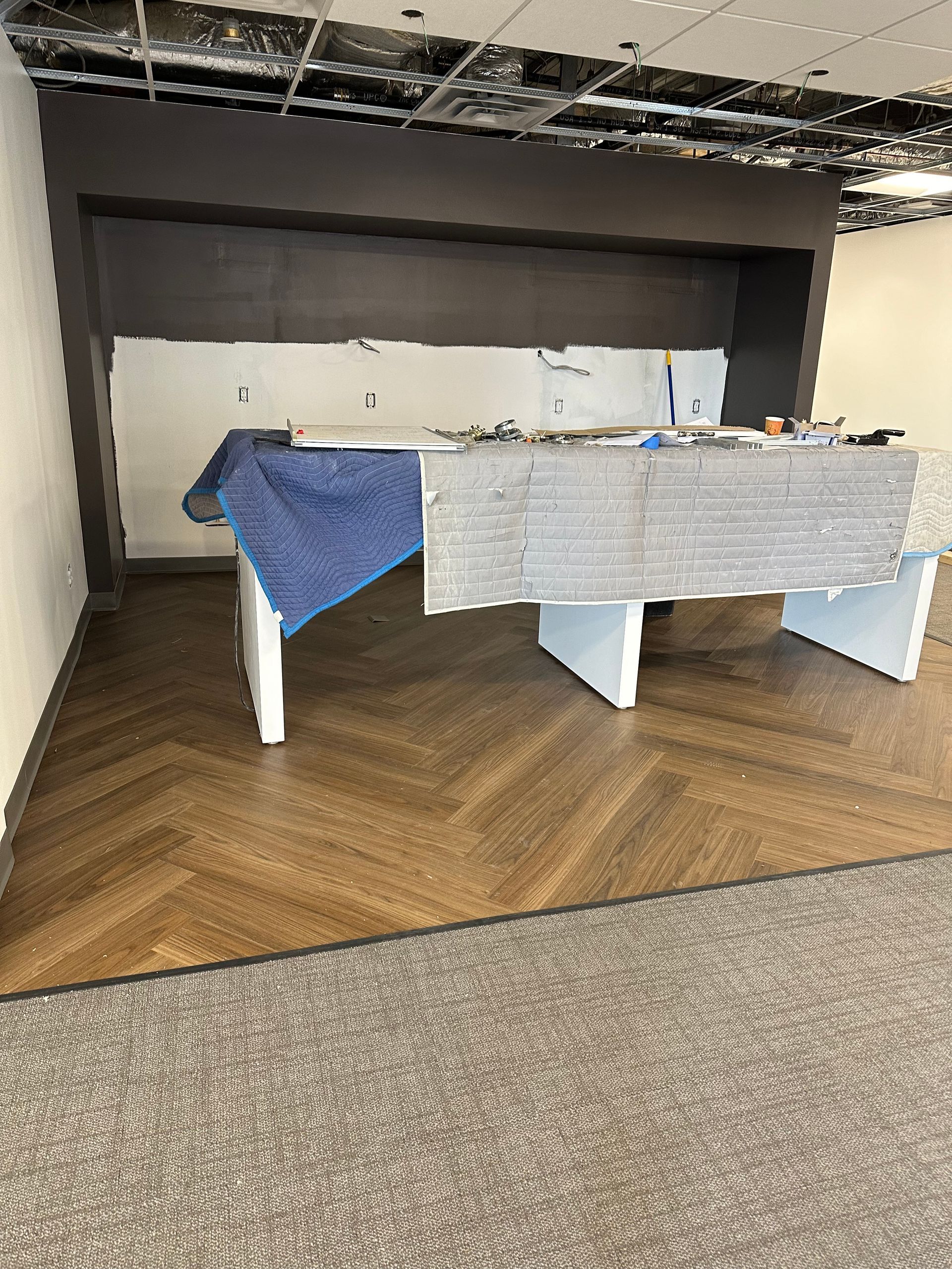 Foosball table in a carpeted lounge area with a blue cloth draped over one side.