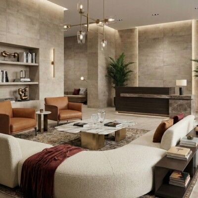 Lobby with brown leather chairs, cream couch, marble coffee table, dark wood reception, and large plant.