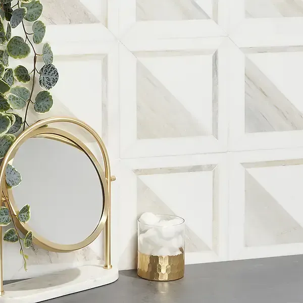 Vanity with mirror, faux plant, and decorative marble-look wall tile.