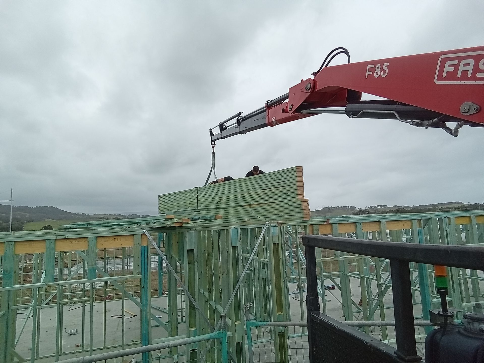 Engineered timber roof trusses crane-lifted into position for a residential construction project in Calderwood, Illawarra.