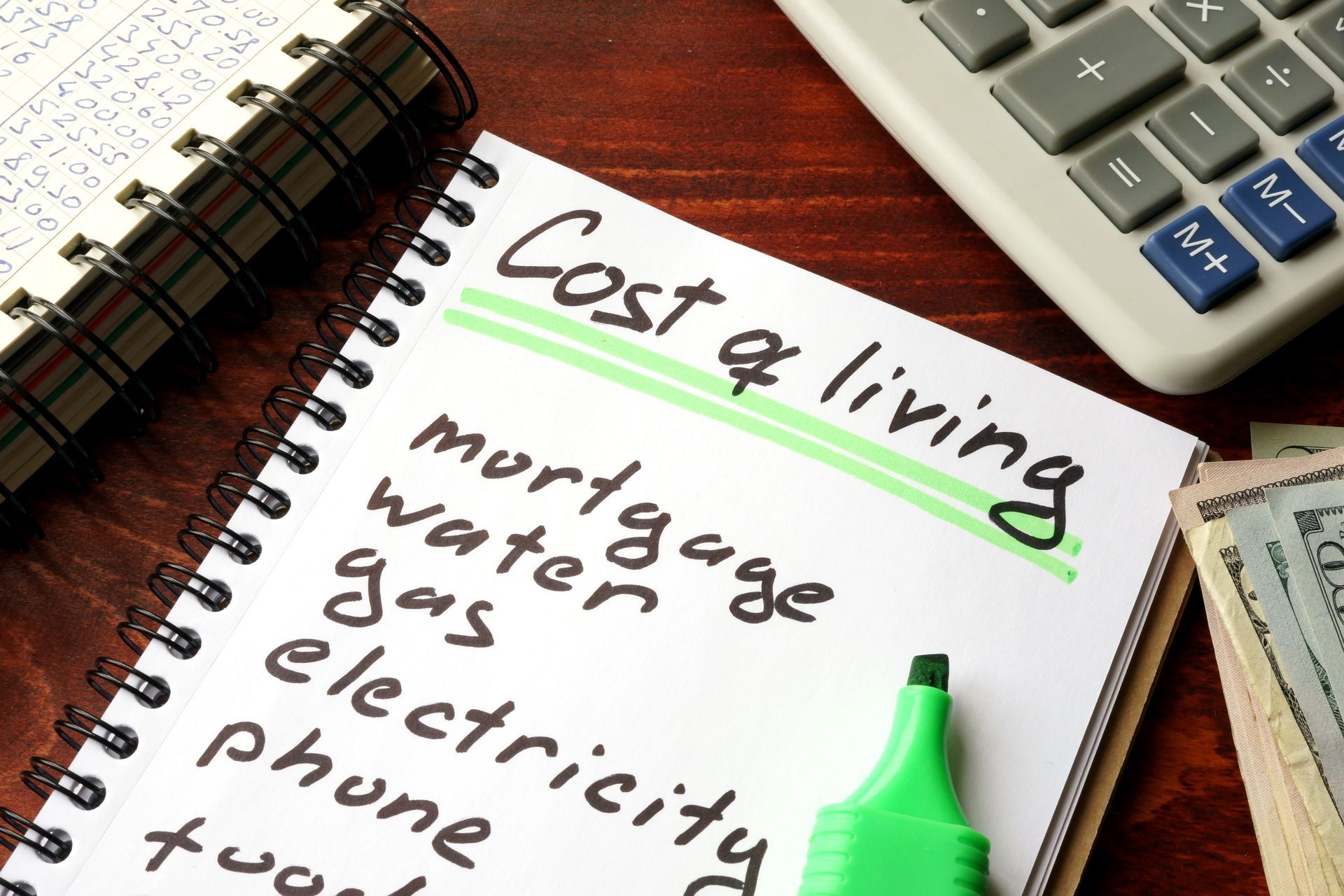 a notebook with the words cost of living written on it