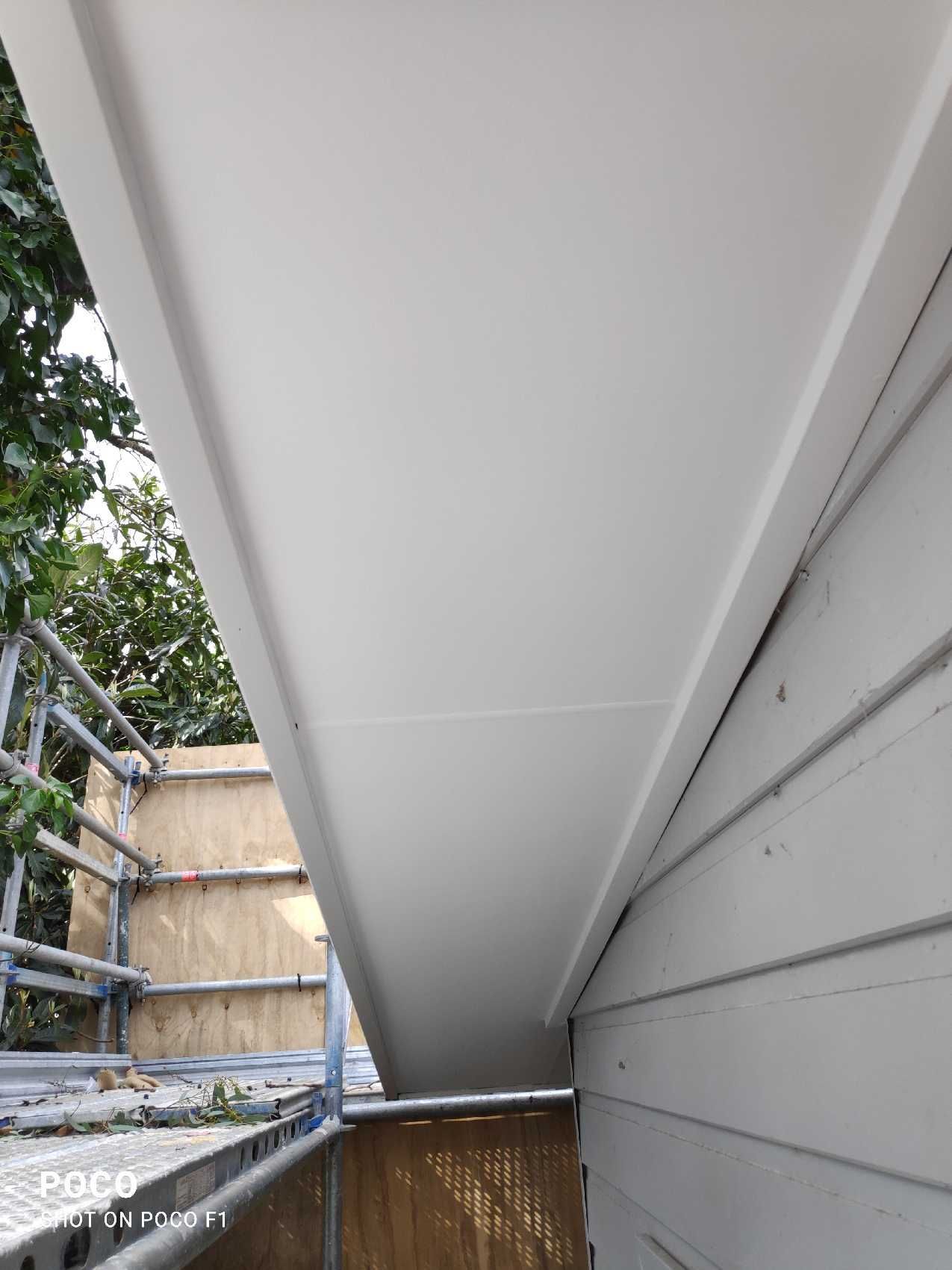 White soffit and trim along a house's roofline. Scaffolding visible.