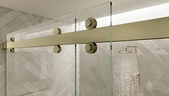 A close up of a sliding glass shower door in a bathroom.