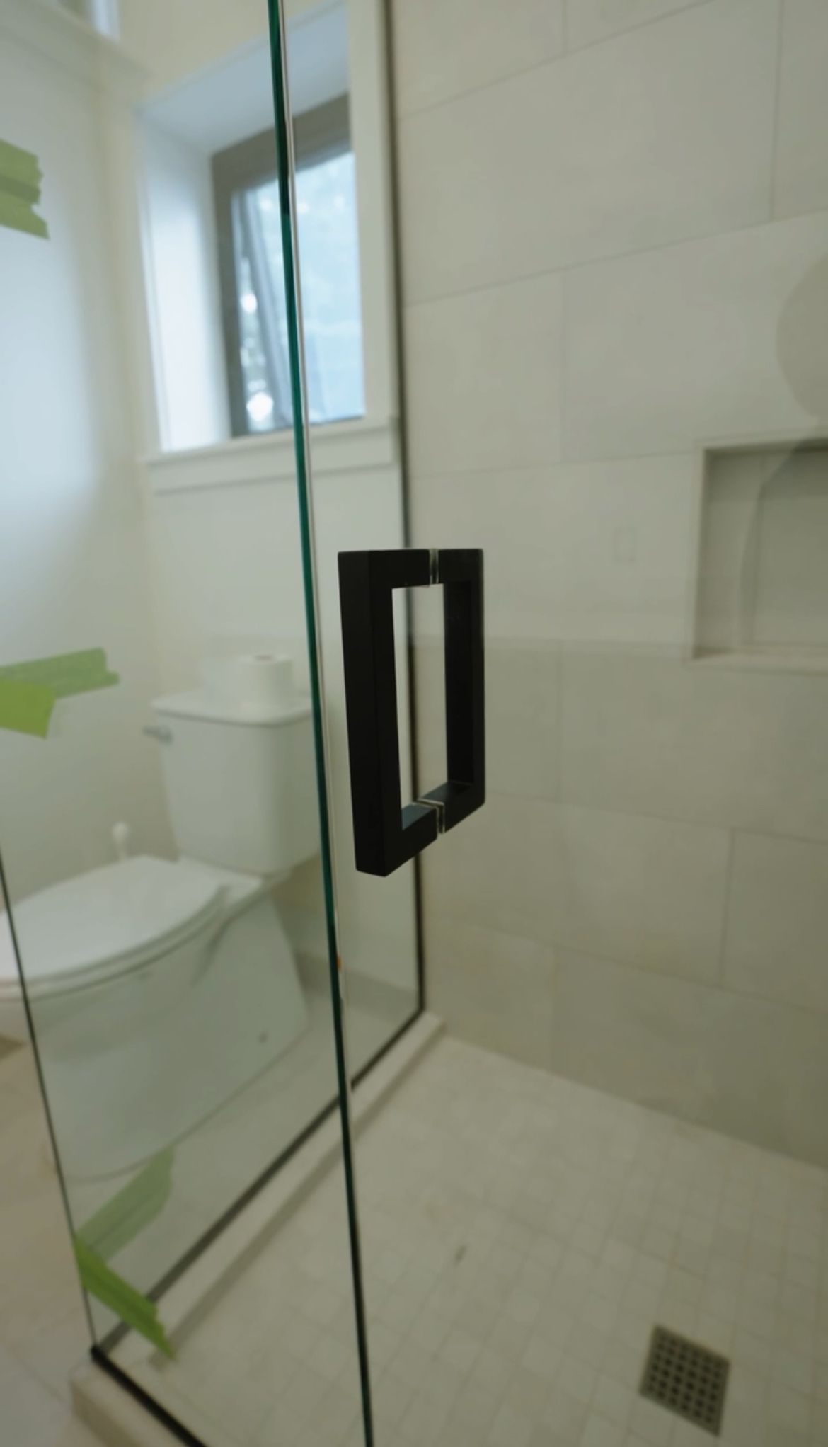 A bathroom with a toilet , sink , shower and mirror.