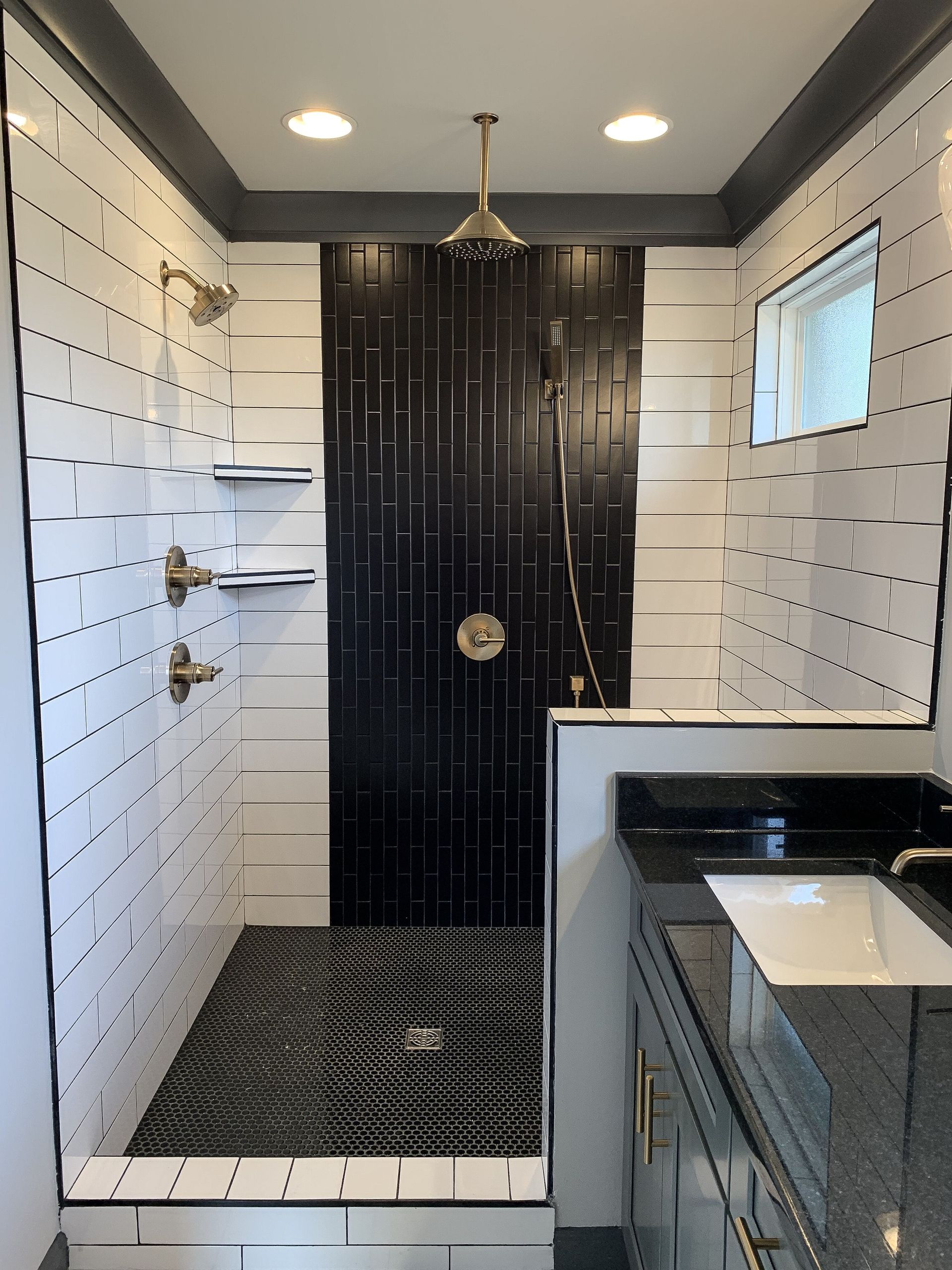 A bathroom with a black and white shower and a sink