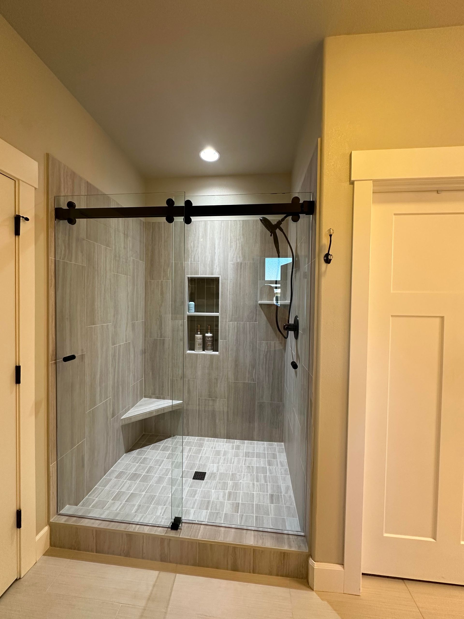 A bathroom with a walk in shower with a sliding glass door.
