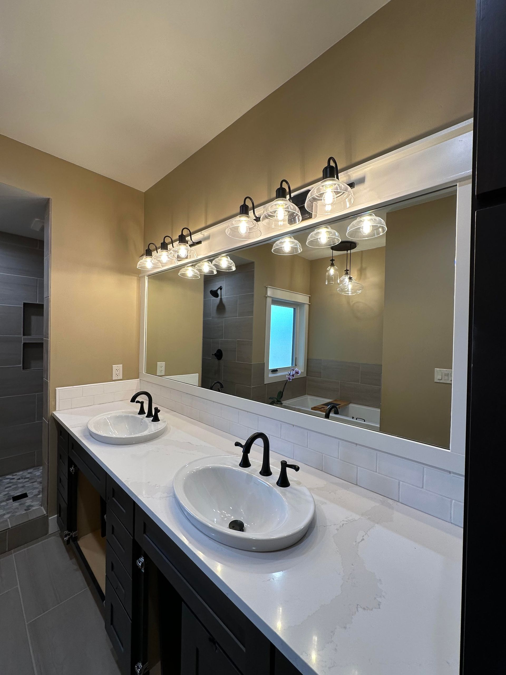 A bathroom with two sinks and a large mirror.