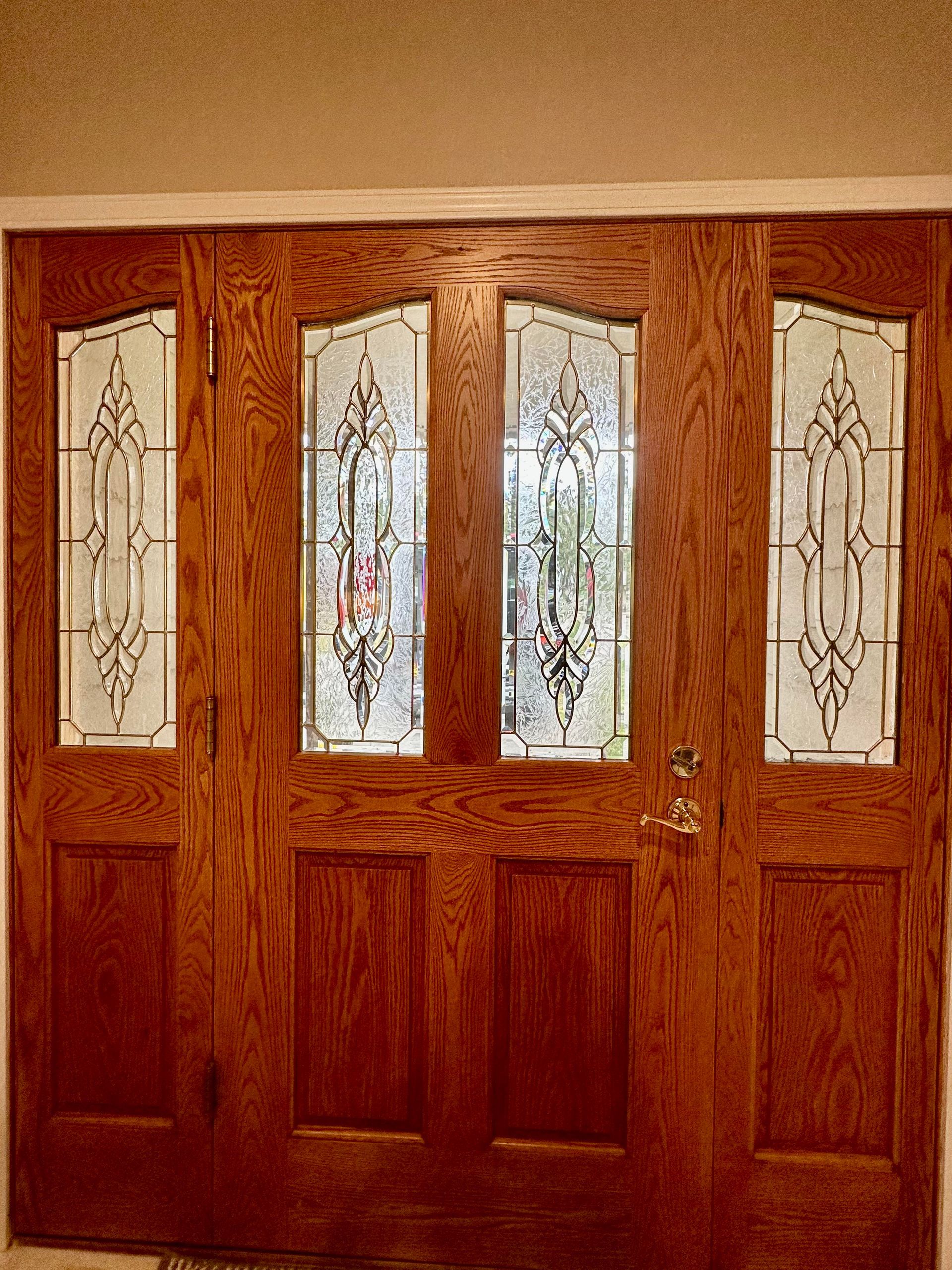 A wooden door with stained glass windows in a room.
