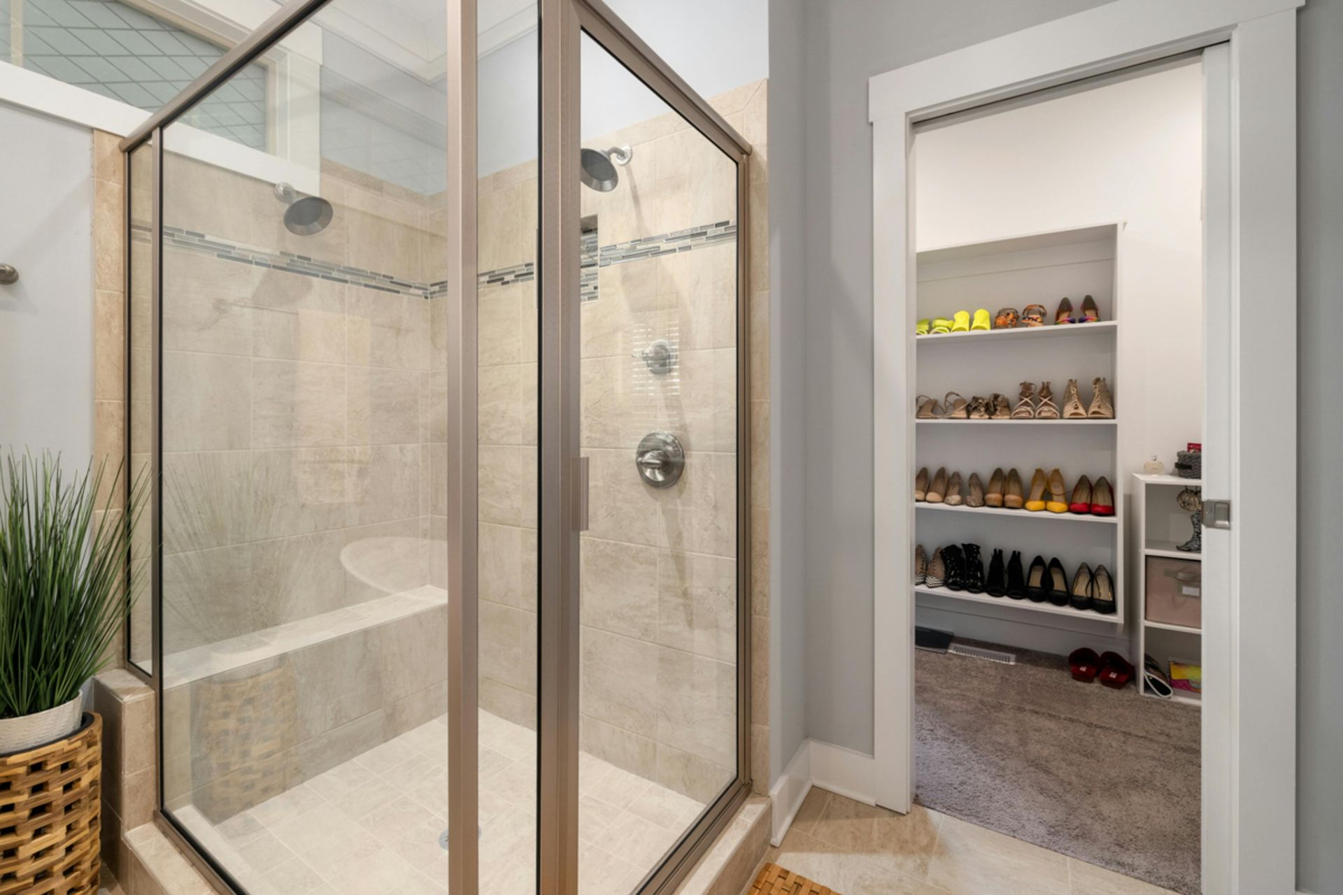 A bathroom with a walk in shower and a closet.