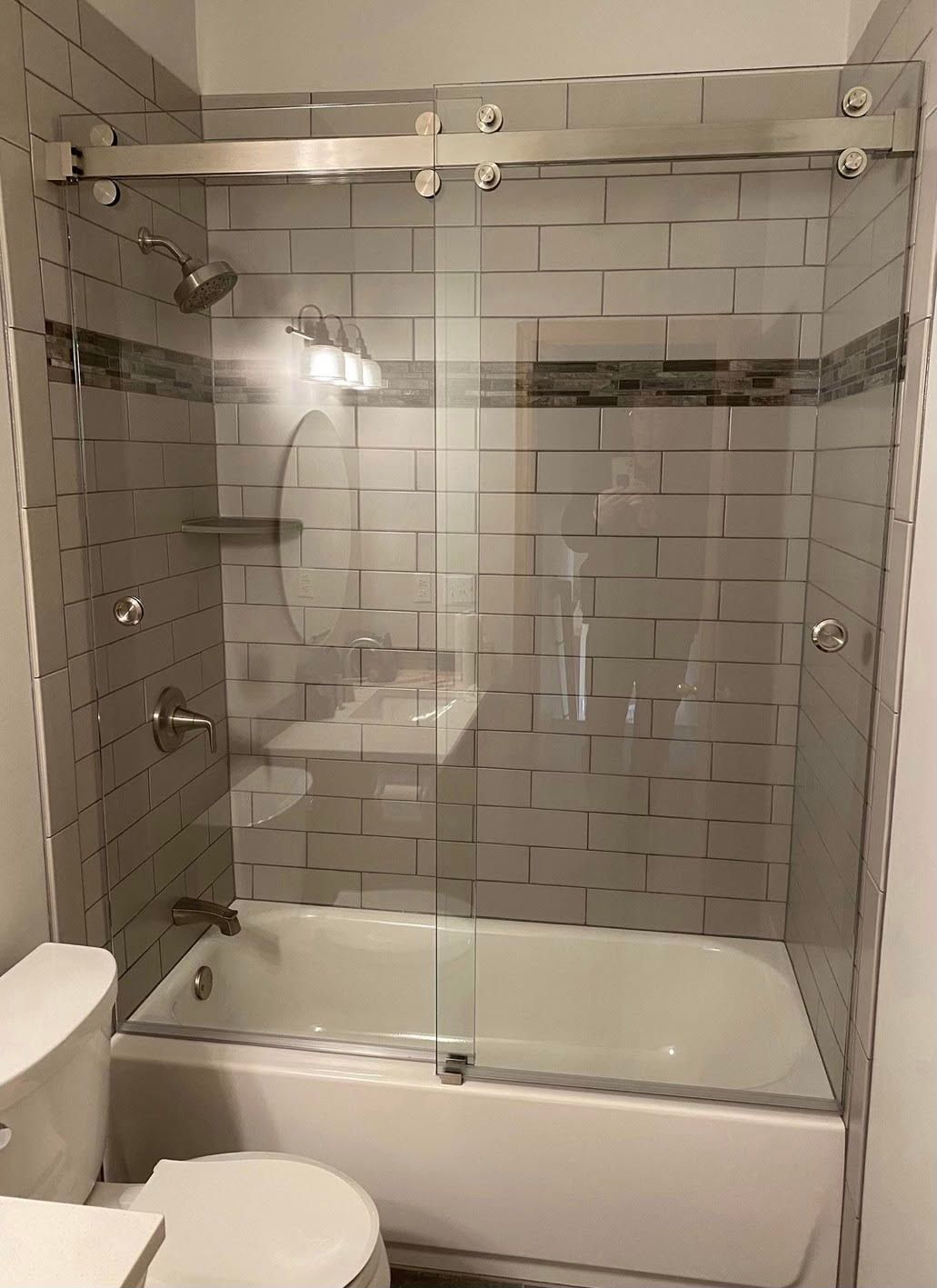 A bathroom with a tub , toilet , sink and shower.