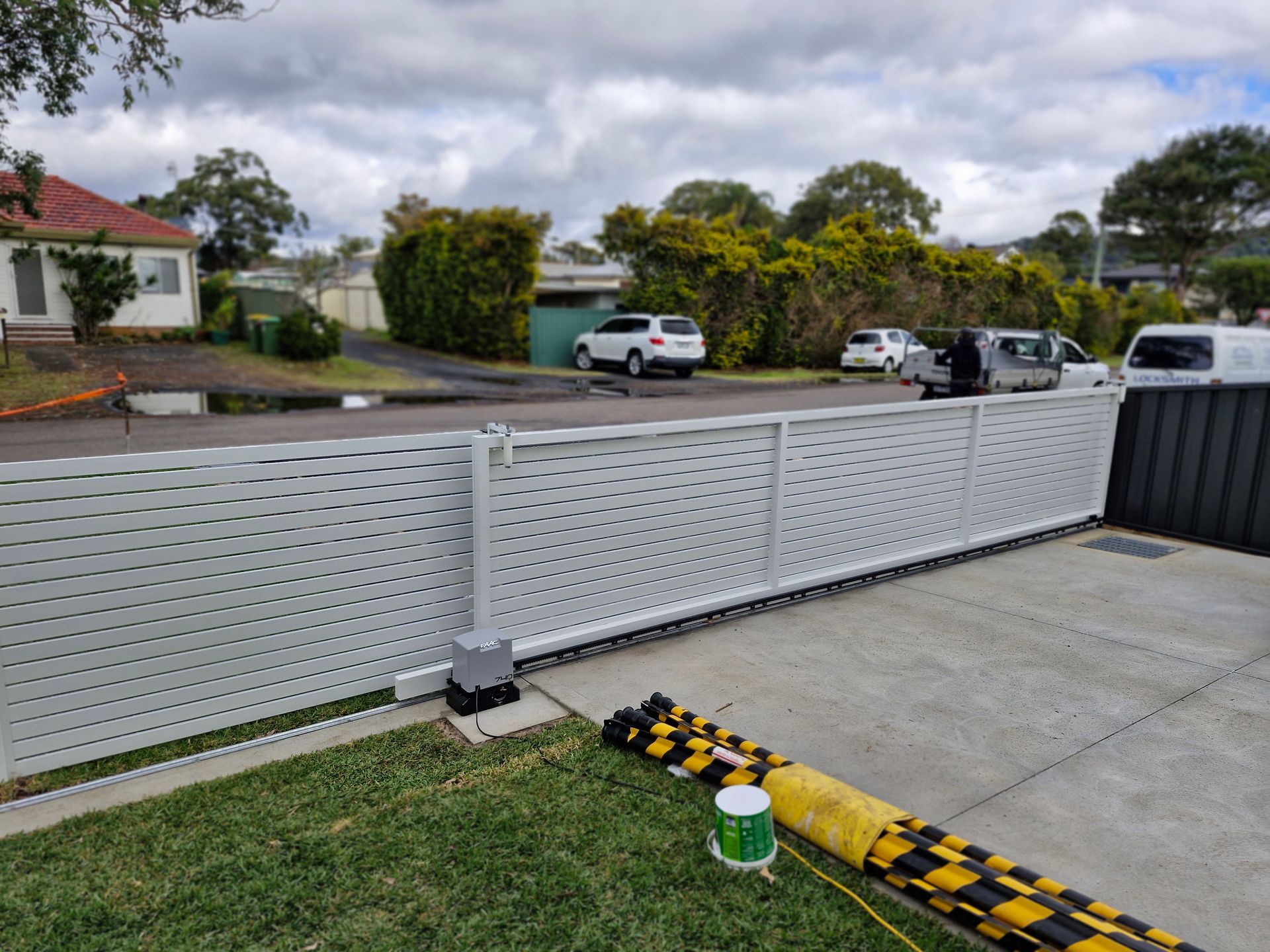 A light gray sliding gate in front of a house. — Strike Fencing & Gates In Tuggerah, NSW