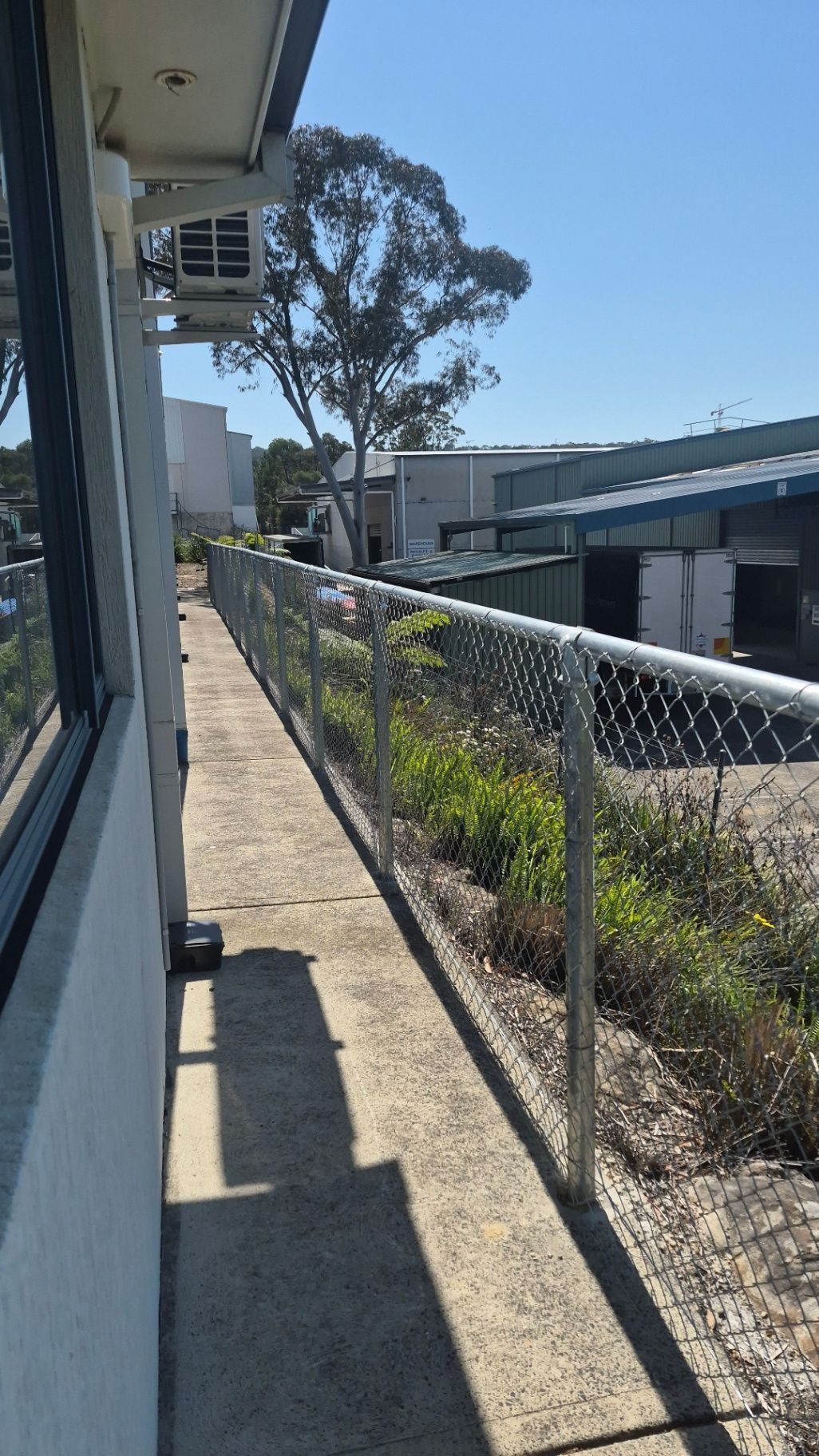 Narrow Concrete Side Yard with A Chain-Link Fence, House Wall — Strike Fencing & Gates In Gosford, NSW