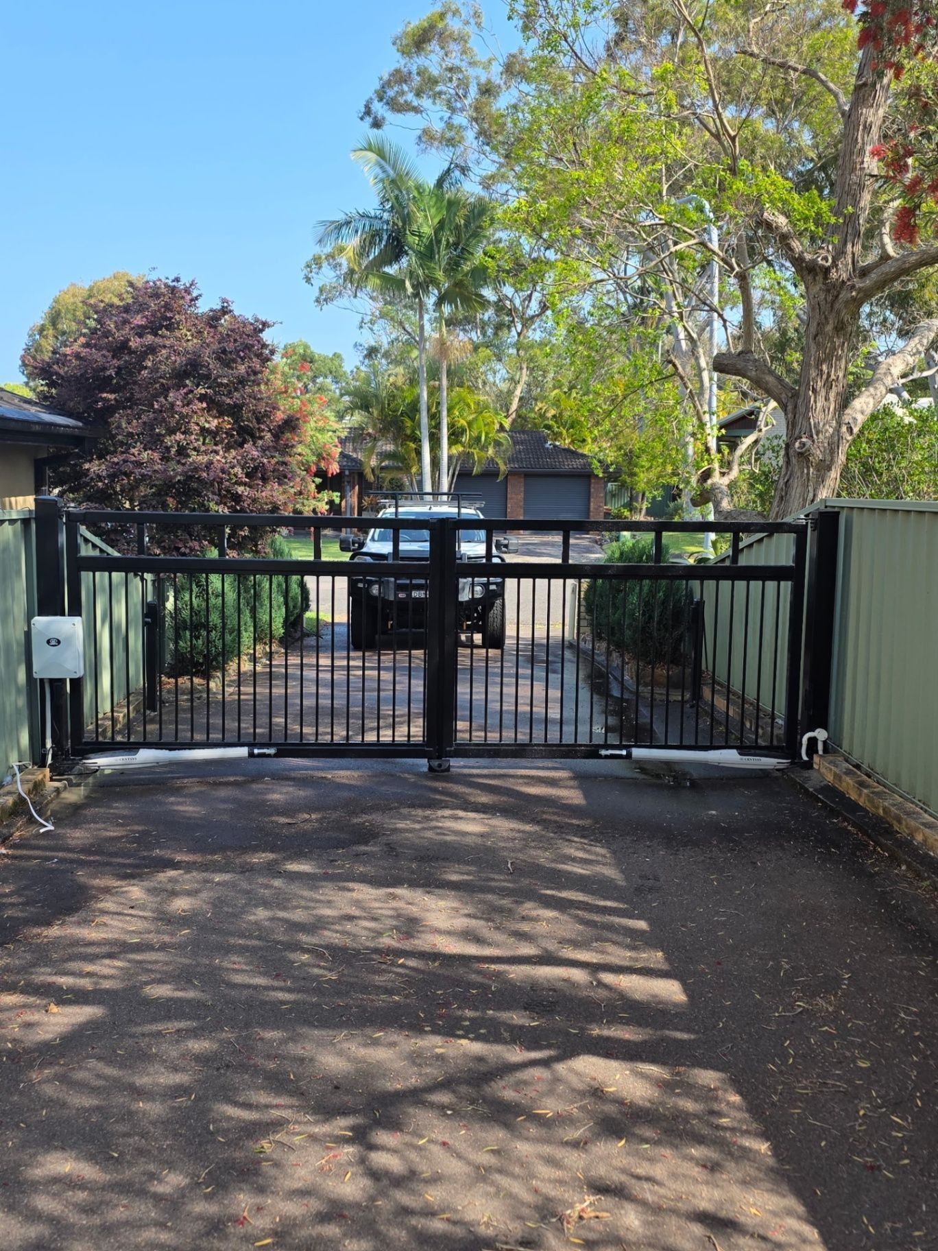 Black Metal Driveway Gate at A Residential Entrance — Strike Fencing & Gates In Tuggerah, NSW