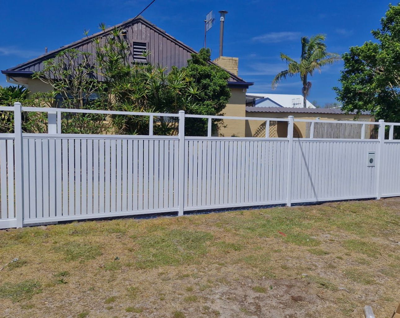 White Slatted Fence With Gate In Front Of A House