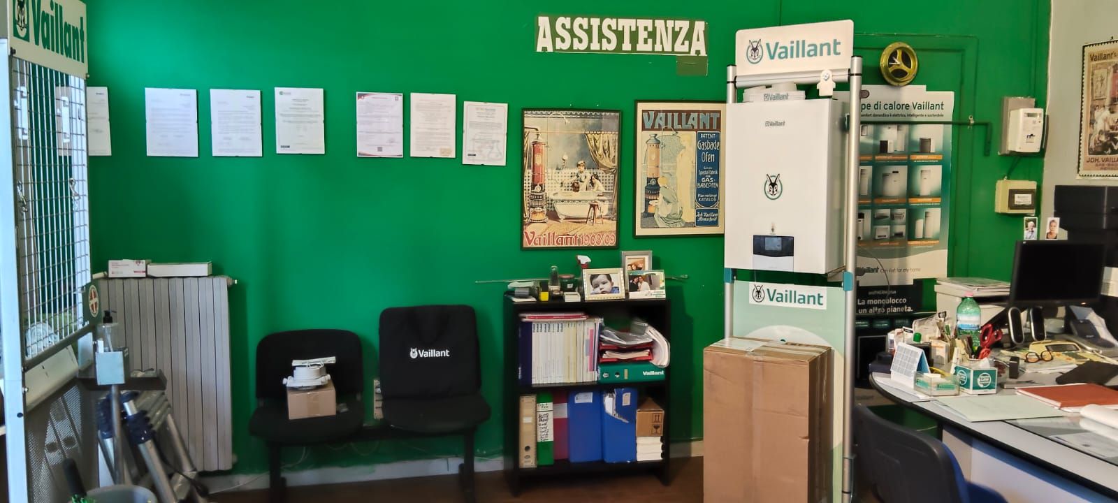 Una stanza con una parete verde e un cartello che dice assistenza