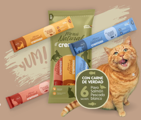 Gato con la boca abierta junto a paquetes de golosinas para gatos, diciendo “¡ÑAM!” y “CON CARNE DE VERDAD”.