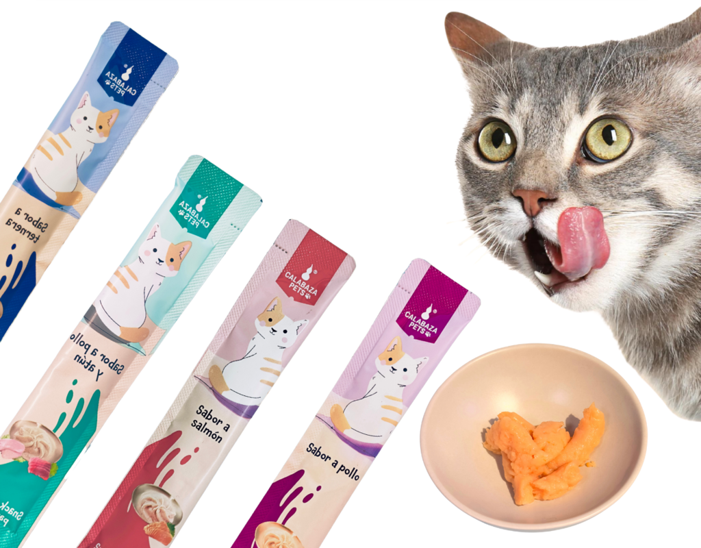 Gato lamiéndose los labios, emocionado por recibir golosinas para gatos en bolsitas de colores en un tazón pequeño.