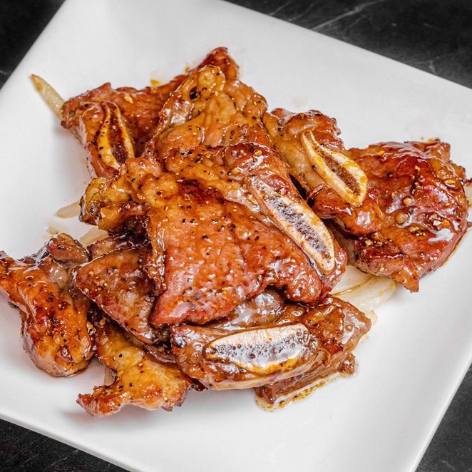 Spicy glazed chicken wings piled on a white plate