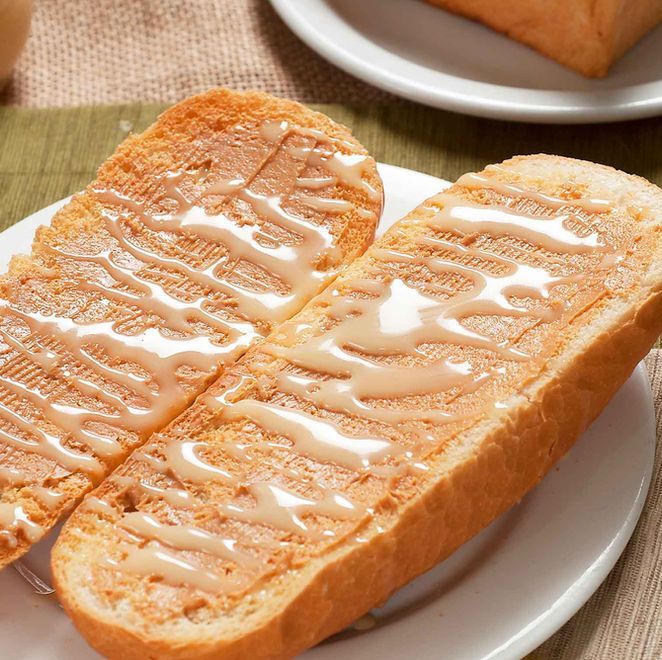 Two slices of toast with melted butter on a white plate