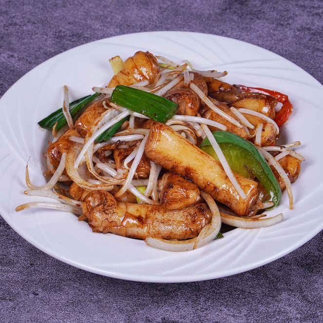 Plate of stir-fried noodles with bean sprouts and green onions on a white dish