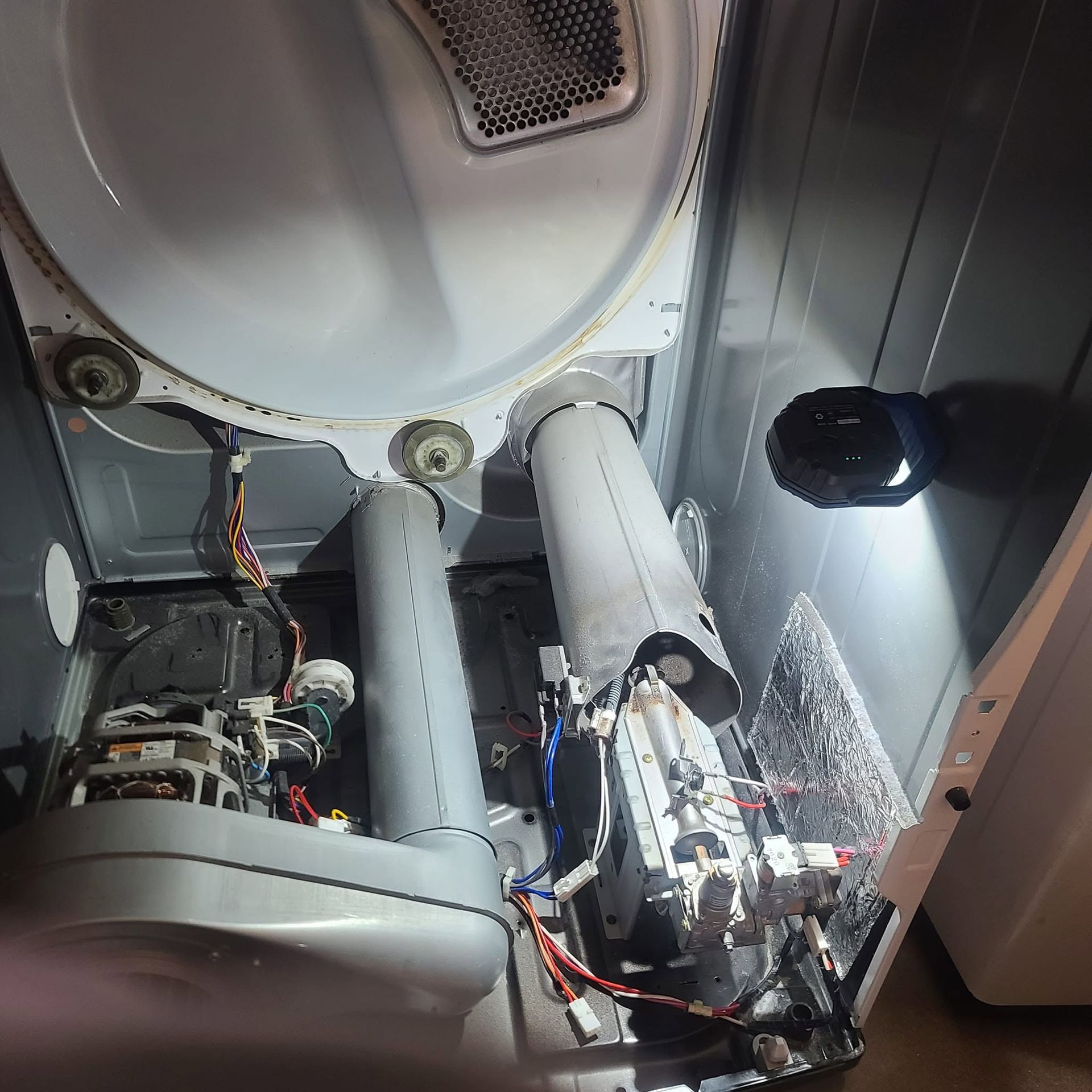 Inside a device, two cylindrical parts and wiring lit by a bright LED lamp.