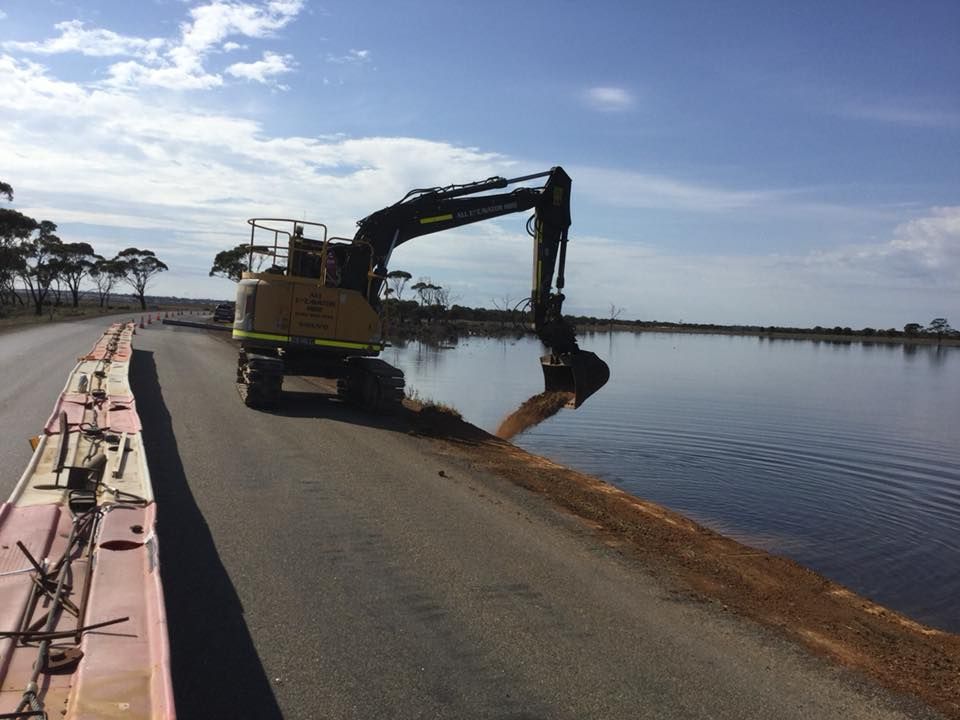 Excavator moving earth for a culvert