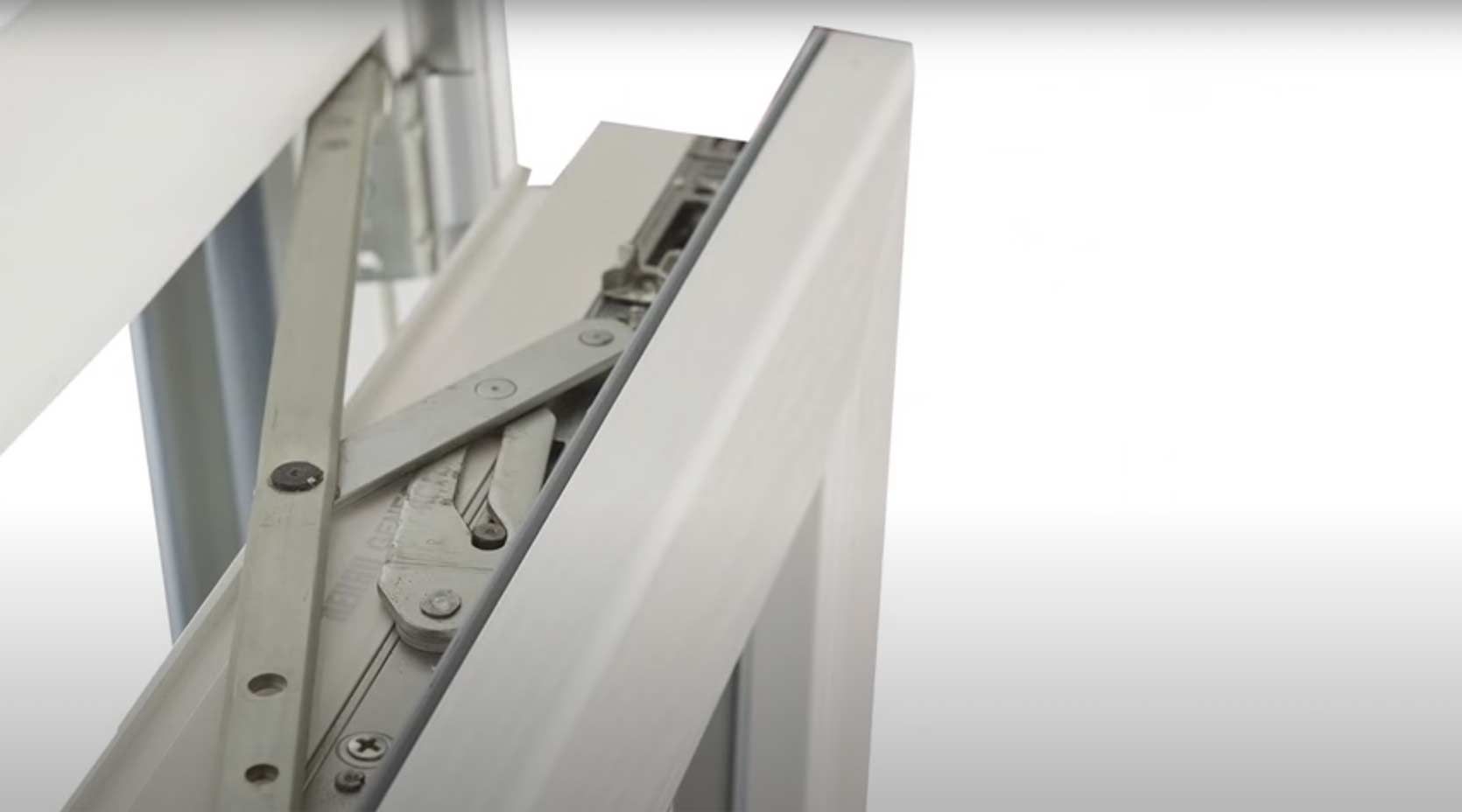 primo piano di una finestra bianca con cerniera in acciaio inox