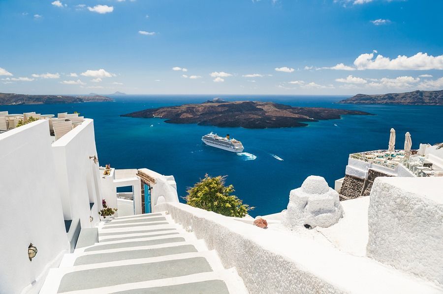 A cruise ship is sailing in the ocean near a small island.