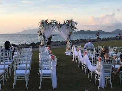 A wedding ceremony is taking place in front of the ocean.