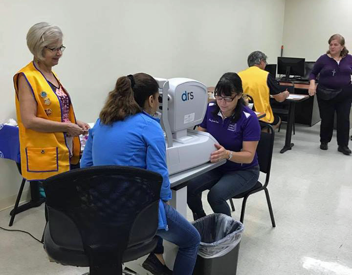 A woman is sitting at a table with a machine that says ars on it.