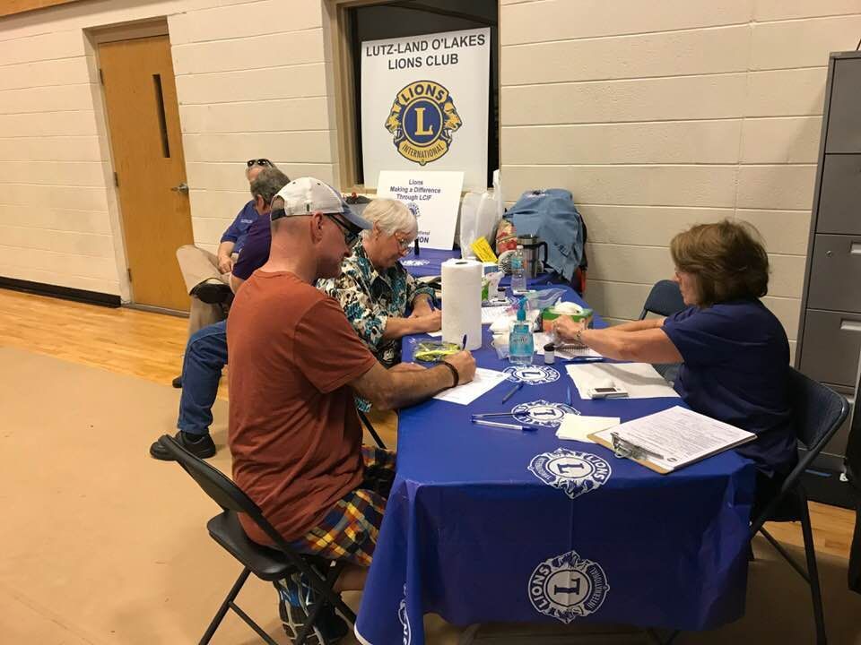 A group of people are sitting at a table with a blue table cloth.