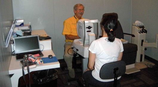A man in a yellow shirt is talking to a woman in a white shirt