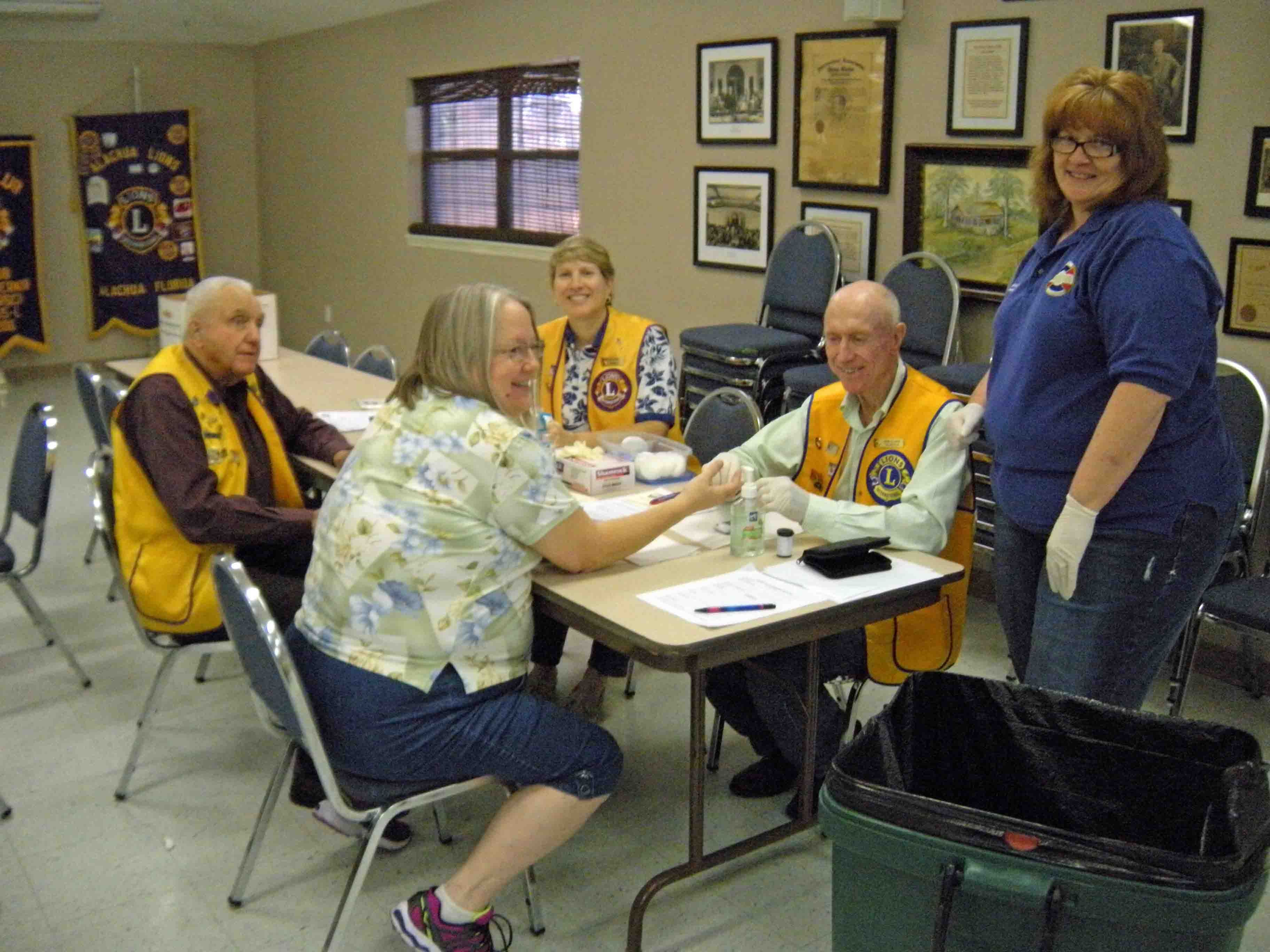 A group of people sitting around a table with lions on their vests