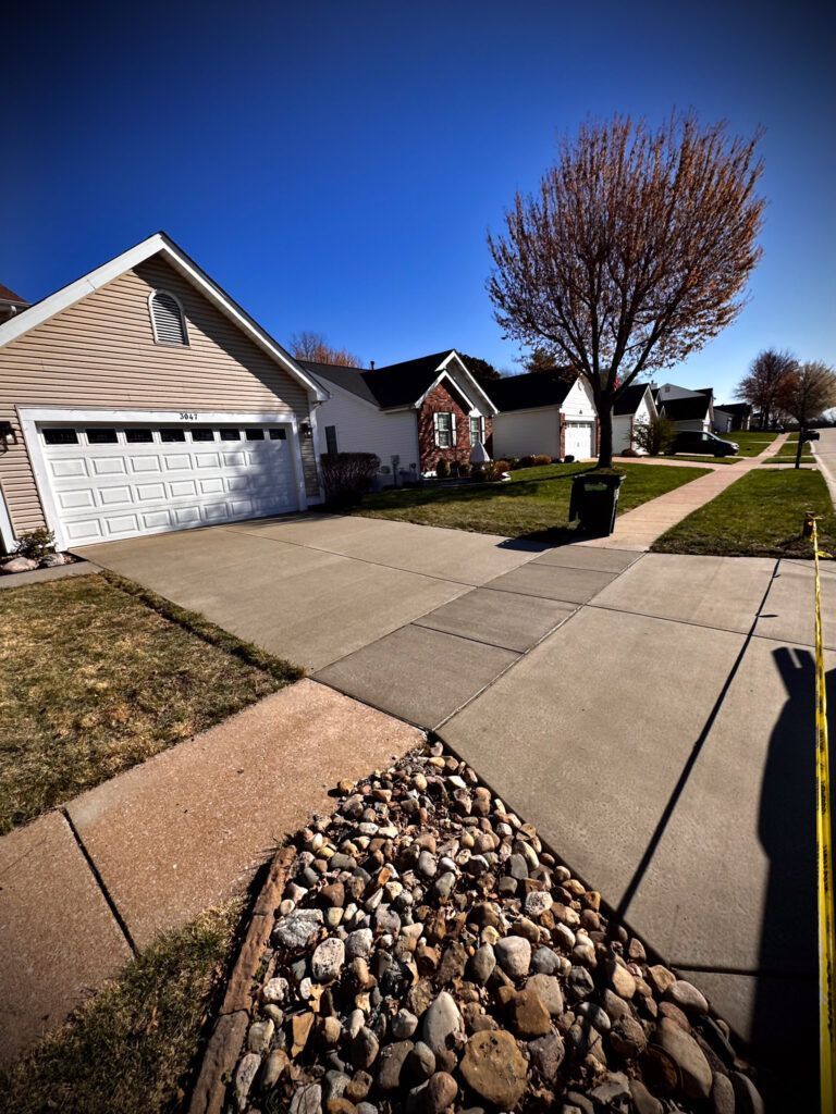 A house with a garage and a sidewalk in front of it